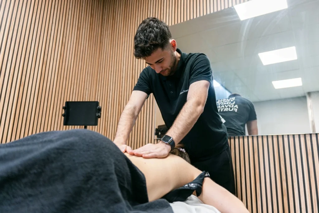 Fisioterapeuta realizando terapia manual en la espalda de una paciente en Girona