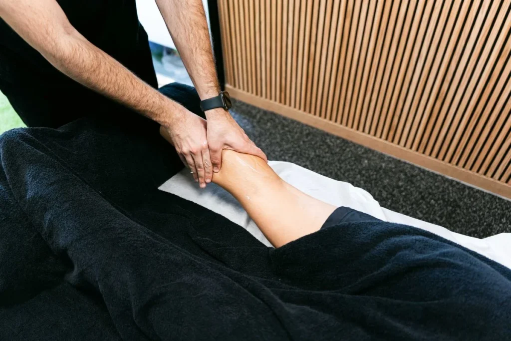 Fisioterapeuta realizando terapia manual en la pierna de una paciente en Girona