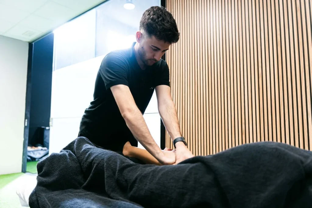 Fisioterapeuta aplicando un tratamiento manual en la pierna de una paciente en Girona