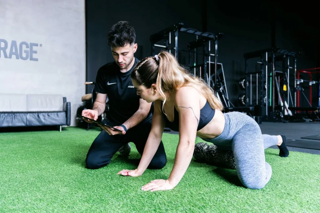 Valoración de readaptación deportiva Fisioterapeuta valorando el movimiento de una paciente durante una sesión de readaptación deportiva en Girona